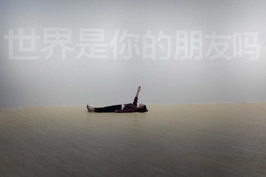 庄伟，前：《Help! Help? Help.》，表演现场，2019（原为2016年影像作品，1分53秒）；后：《世界是你的朋友吗?》，2019，油漆、墙面，尺寸可变，300 x 1500 cm；图片提供：华宇青年奖；摄影：袁启峰.