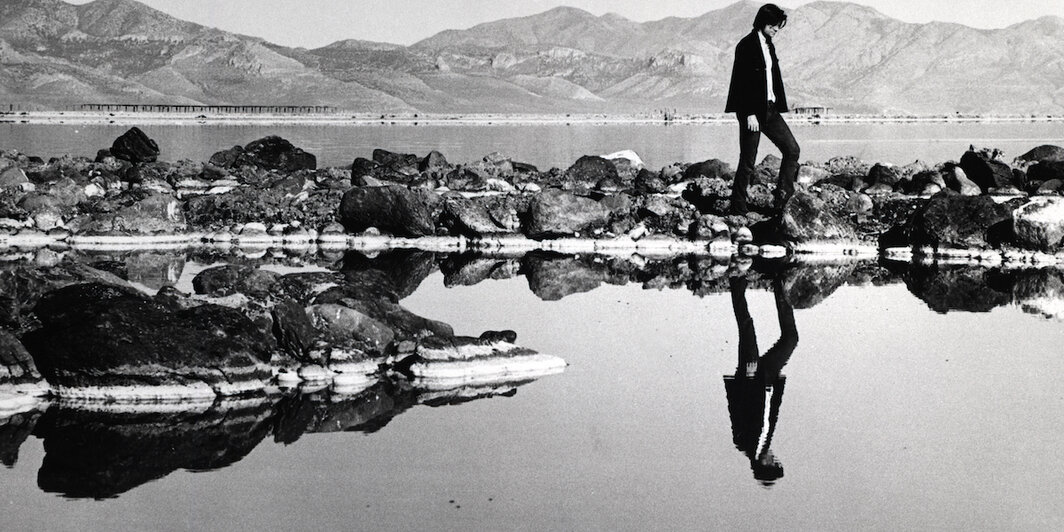 罗伯特·史密森在“螺旋形防波堤”上，1970年，大盐湖，犹他州. 摄影：詹弗兰科·戈尔戈尼（Gianfranco Gorgoni）. © 南希·霍尔特/史密森基金会 / 纽约艺术家产权协会.