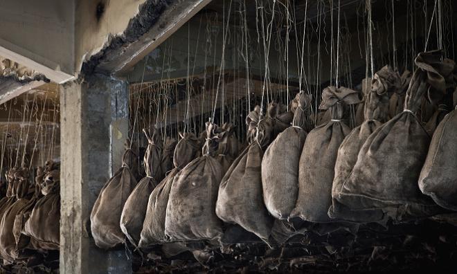 马塞尔•杜尚、《100打煤袋》、1938/2012, 煤袋，金属火盆。展览现场：比利时根克沃特斯黑煤矿，2012。&nbsp;