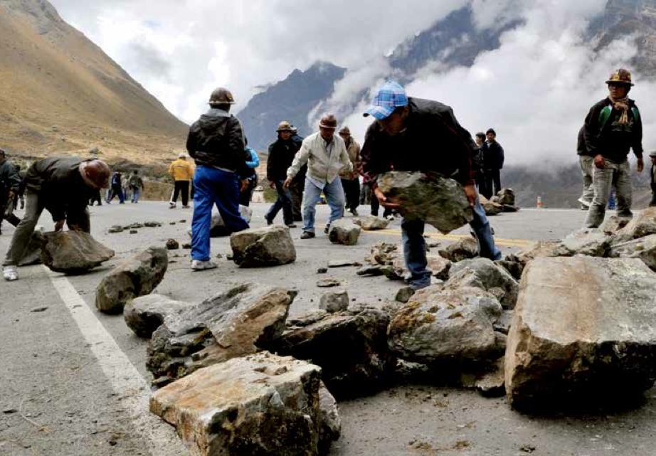 矿工在通过玻利维亚拉巴斯的路上放置石块作为路障，2012年9月25日. 摄影：法新社/Aizar Raldes Nuñez.