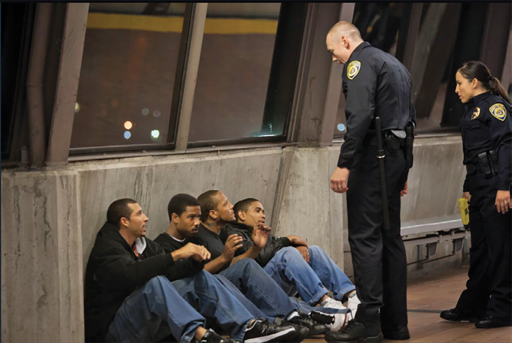 瑞恩·库格勒，《弗鲁特韦尔车站》，2013，超16毫米，彩色，有声，85分钟；左起第二人为奥斯卡·格兰特，由Michael B. Jordan饰演.