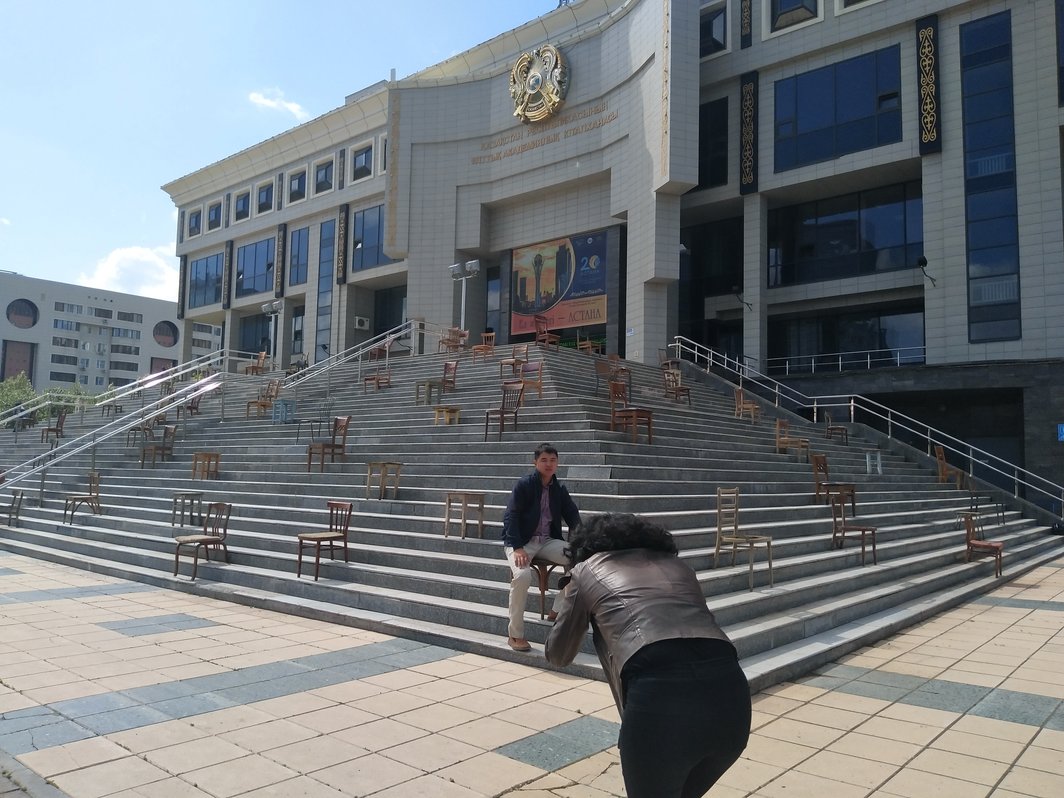 国家图书馆前Askhat Akhmenyarov的作品，策展人Aigerim Kapar正在为游客拍照.