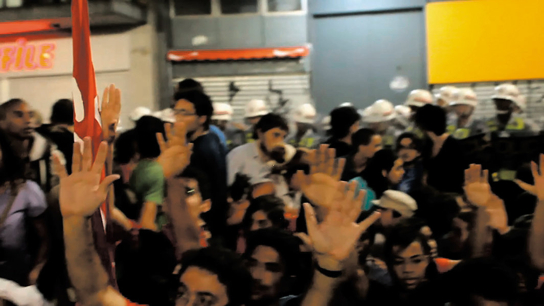  克拉拉·伊恩尼，《圈》，2016，综合材料装置里的数码录像（彩色有声，时长8分28秒）静帧，其他组成材料包括墙面文字和分界胶带. 