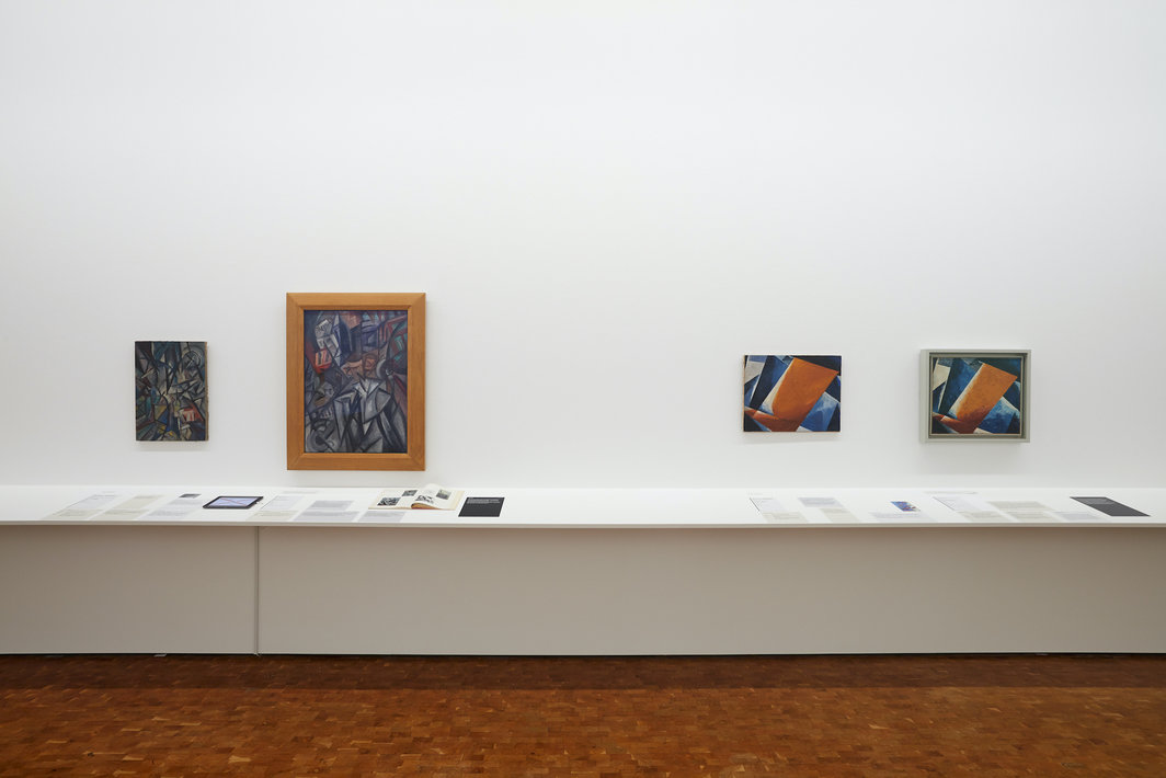 “路德维希博物馆的俄罗斯先锋派艺术：真品与伪作”展览现场，2020-2021年. 左：两幅被判断为奥尔加·洛扎诺娃的画作，1913年. 右：两件被认为是勒尤堡·珀波瓦的《绘画建筑》的作品，分别创作于1920和1918年.