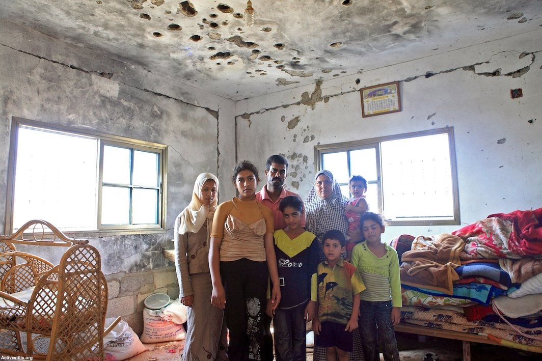 一个巴勒斯坦家庭在他们被以色列“铸铅行动”期间炮轰过的房子里. 他们在轰炸过后10个月再次搬进了这个房子生活，贝特汉诺镇（Beit Hanoun），加沙，2010年8月. 摄影：安·帕克.