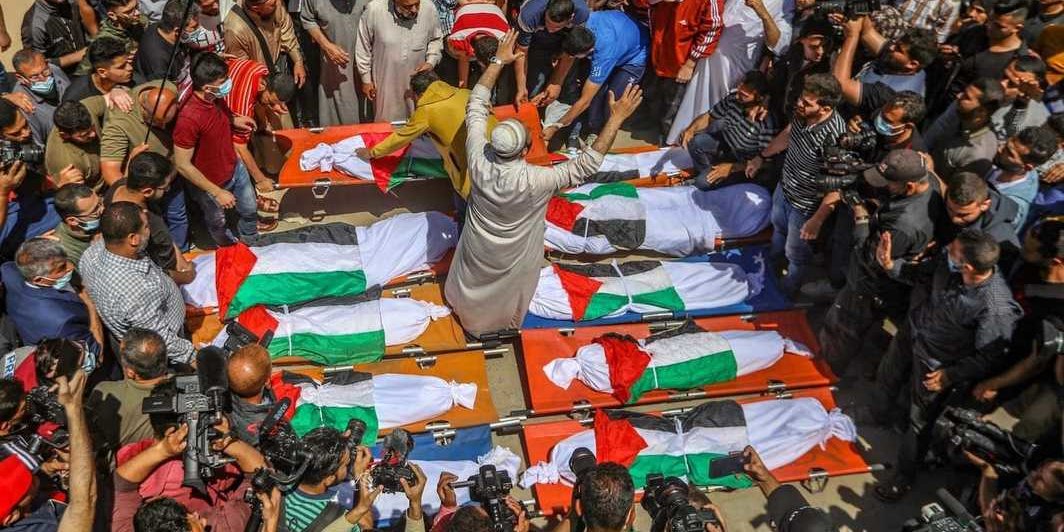 巴勒斯坦人参加Abu Hatab家族的葬礼，加沙，2021年5月15日. 以色列空袭后一栋沙提（Shati）难民营的楼房倒塌，造成两名妇女和八名儿童死亡. 当时这家人正在庆祝开斋节. 目击者称事先并未得到空袭警报. 摄影： Mahmoud Zaanoun.