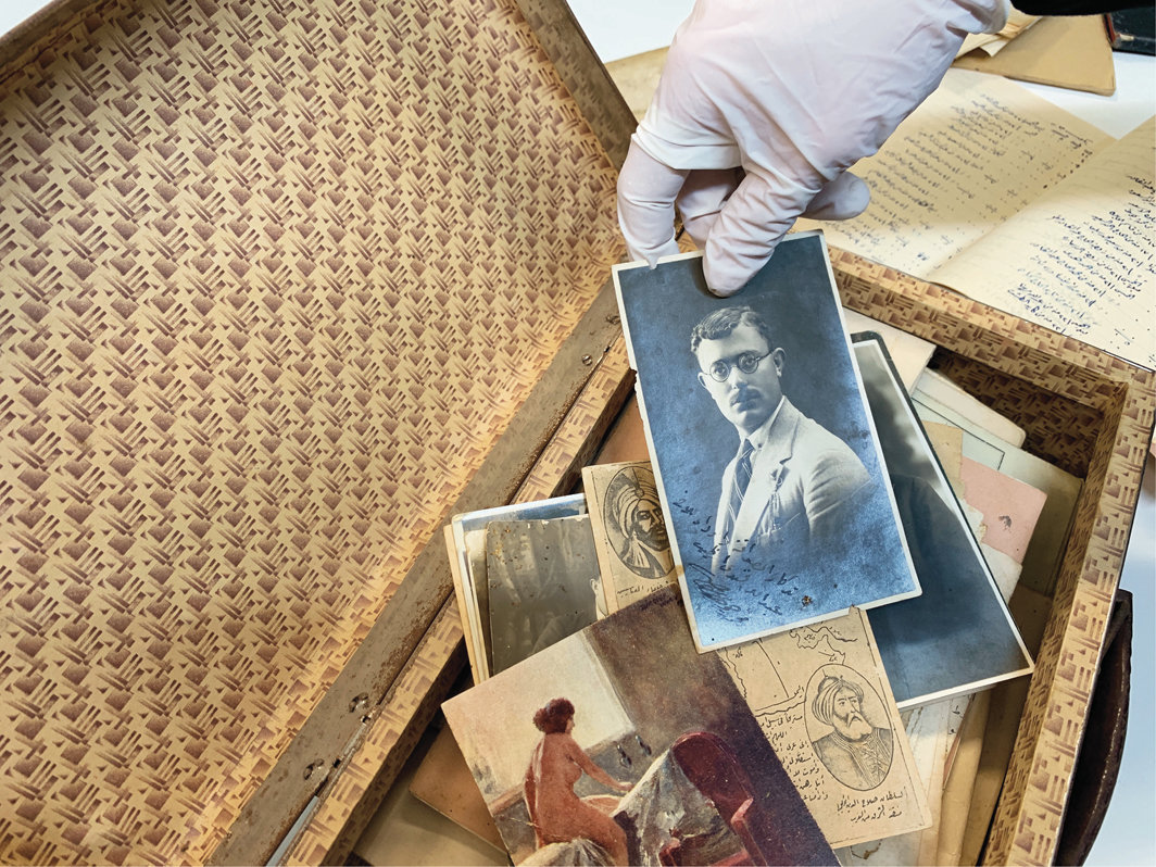 一位研究者正翻阅 Sakhr al-Khateeb的照片和纪念品收藏，这些藏品可追溯至1920年代，2019年1月. 巴勒斯坦博物馆数字档案. 摄影：Haneed Saleh.