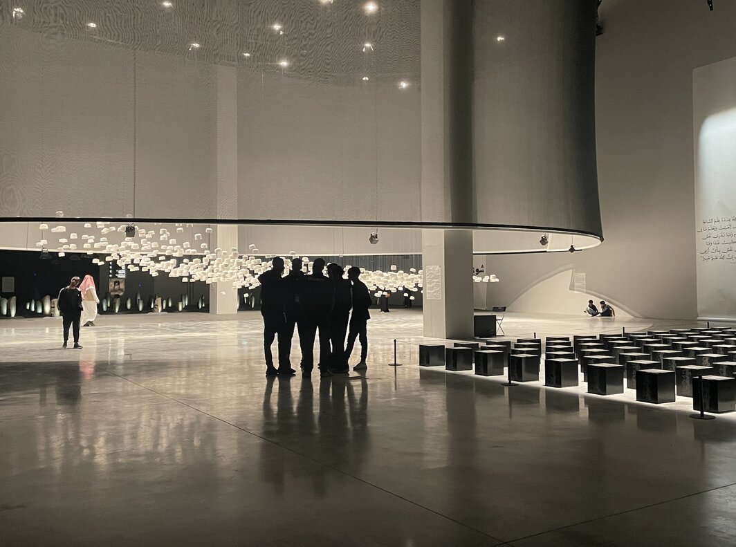 首届伊斯兰艺术双年展现场，展览非高峰时段，安保工作人员在展厅内休息聊天. 