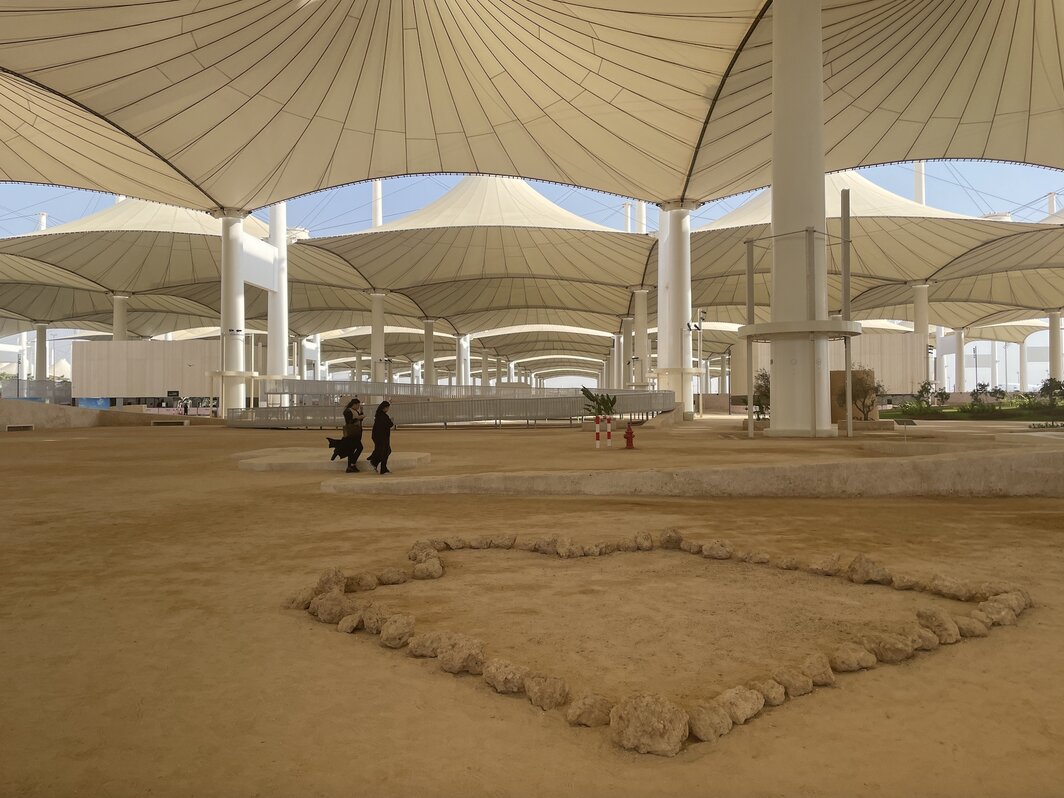 朝觐航站楼的半露天建筑下，策展人Sumayya Vally和艺术家 Moath Alofi共同根据空间环境还原了一些住在沙漠中的信徒会实践的做法——用泥土石头简单地圈划出一片朝向麦加方向的神圣空间.