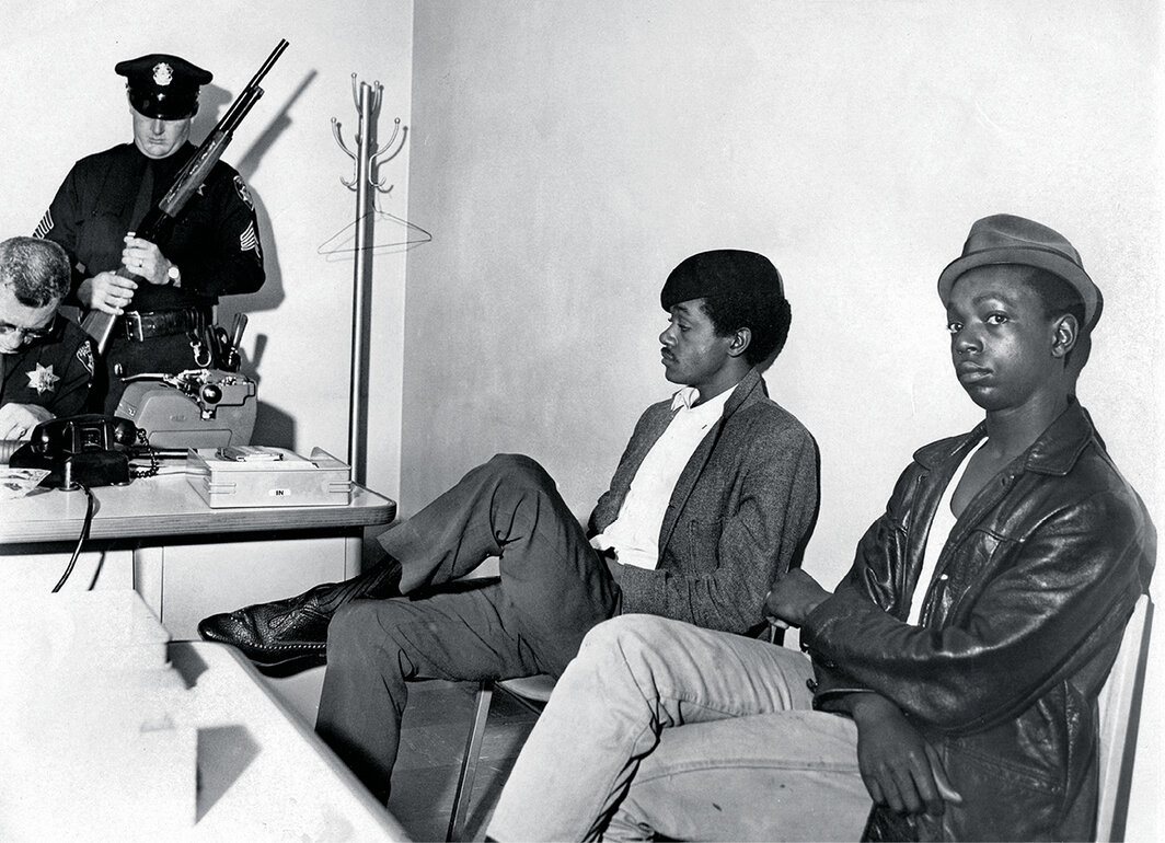鲍比·赫顿和鲍比·西尔被奥克兰警察局拘留，警察在检查他们的枪支，1967. 摄影：Ron Riesterer. 