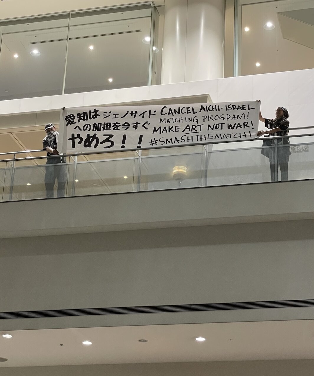 开幕式结束后在三楼拉横幅的抗议者.