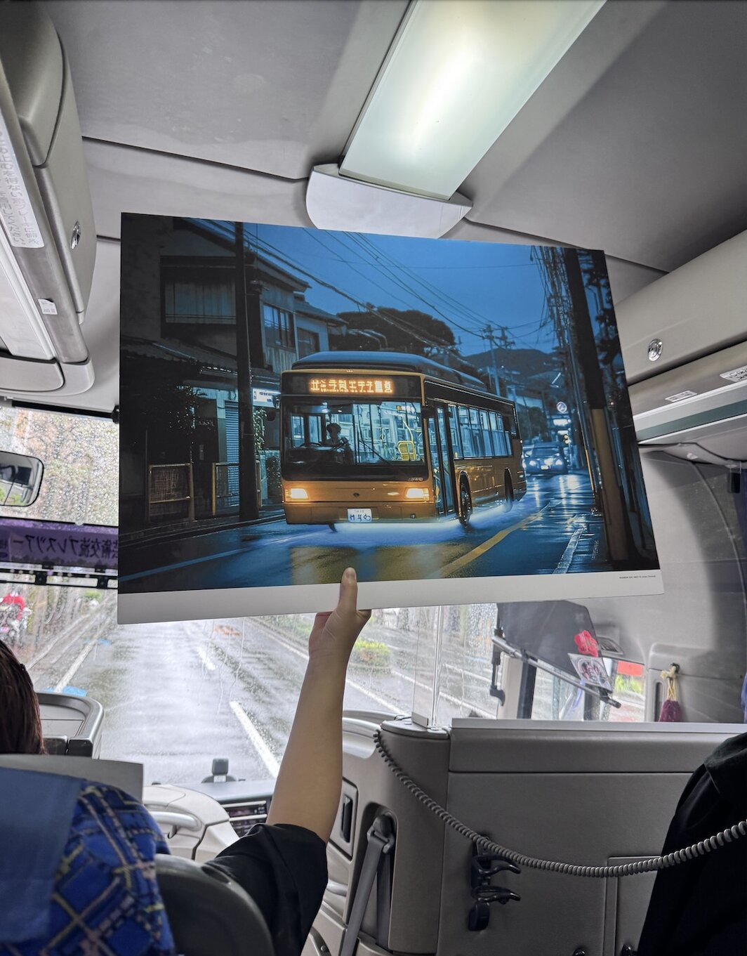 工作人员在大巴上用KT板展示不一定能被媒体团看到的参展作品.