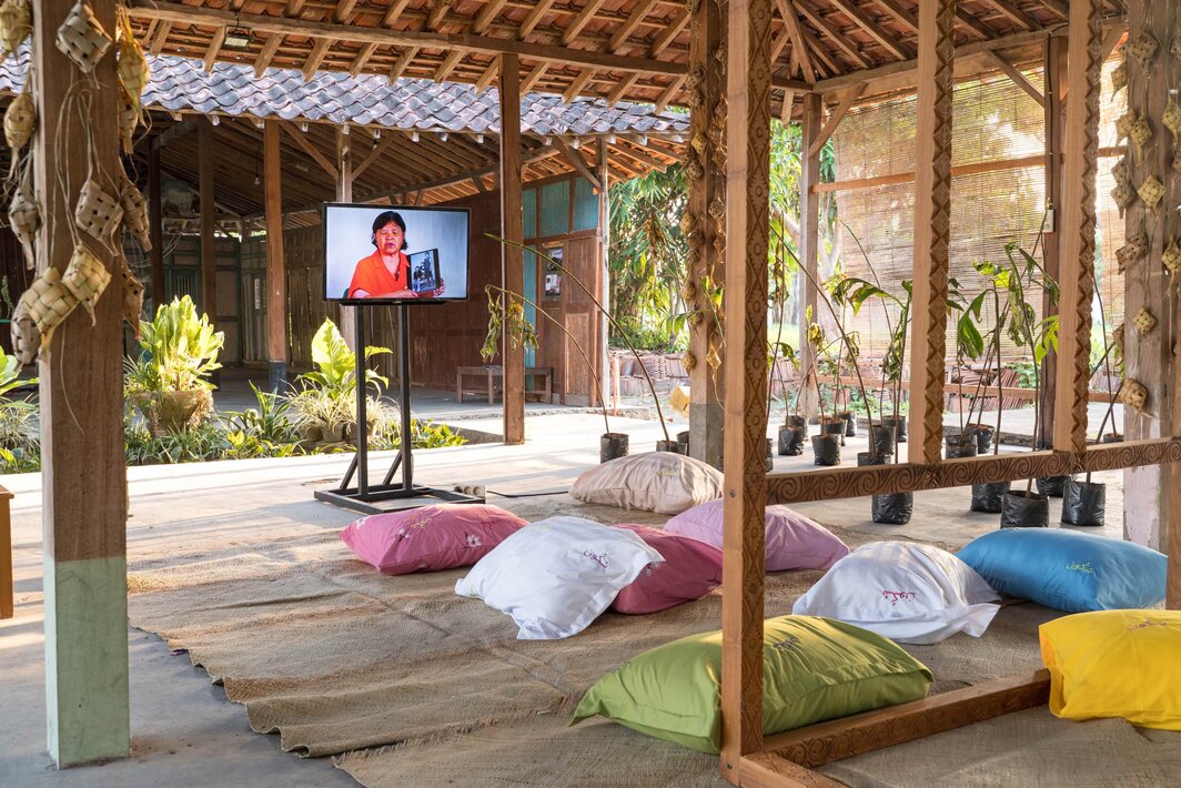 纳塔莉·穆查马德，《面包果/休息，让我们造反吧》（Sukun, let’s mutiny），2025. 装置：木结构温室、绣字枕头、录像《从一个岛到另一个》（时长7分钟）、椰叶编织、藤席. 致谢：艺术家、日惹双年展.