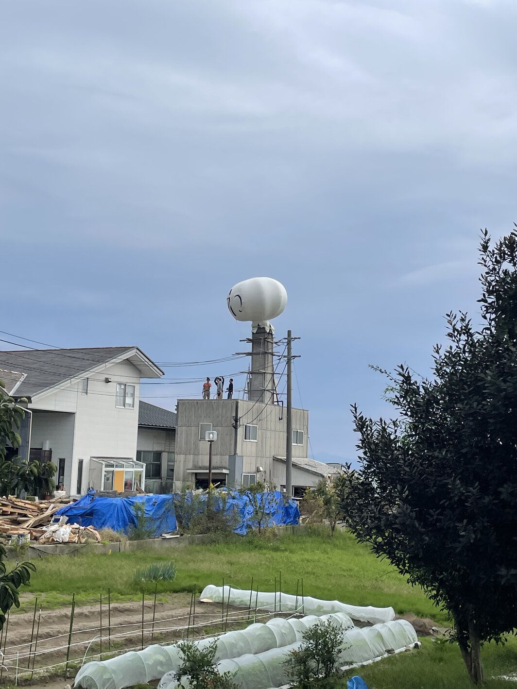 在珠洲市“海滨阿弥陀汤”（Kaihin Amidayu）房顶安装热气球作品的艺术家们，2025年10月18日.